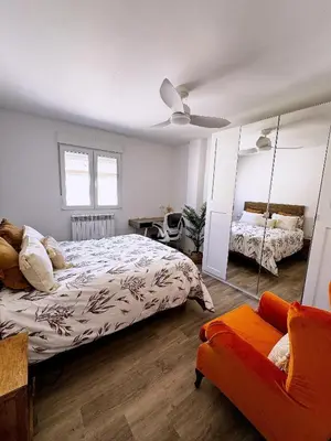 a bedroom with a bed and a mirror and a couch at Moderno Piso en Puerto Sagunto in Puerto de Sagunto