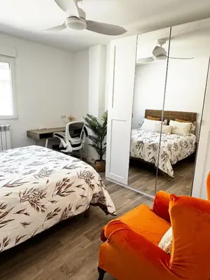 a bedroom with a bed and a mirror and a desk at Moderno Piso en Puerto Sagunto in Puerto de Sagunto