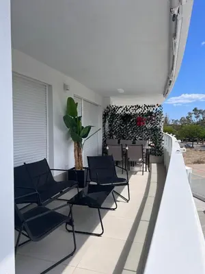 a balcony with chairs and a table and a plant at Espectacular apartamento en Gran cannet in Canet de Berenguer