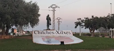 a statue of a man in a park with a sign at Apartamento Chilches Vistas al mar in Chilches