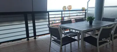 a table and chairs in a room with a balcony at Apartamento Chilches Vistas al mar in Chilches