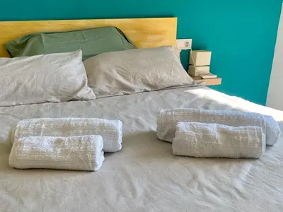 a white bed with three pillows on it at Mi Oasis Azul Parking, AC, Fibra, VT-54949-V in Sueca