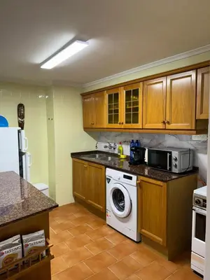 a kitchen with a washing machine and a microwave at precioso apartamento a 10 metros de la playa in Cullera