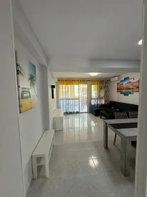 a living room with a table and a couch at precioso apartamento a 10 metros de la playa in Cullera