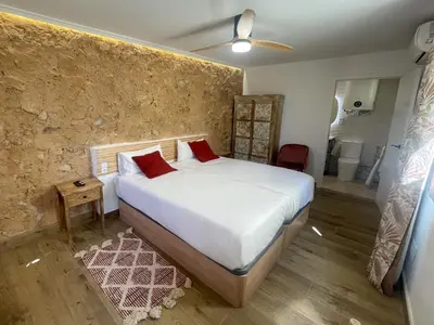 a bedroom with a bed with white sheets and red pillows at Hotel Boutique - Estancia dos Olivos in Quesa