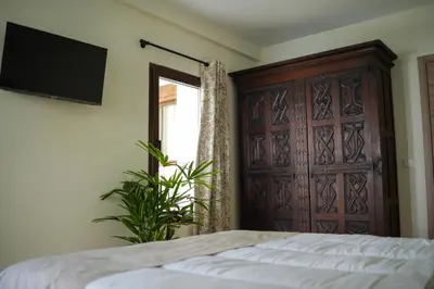 a bedroom with a bed and a large wooden door at Hotel Boutique - Estancia dos Olivos in Quesa