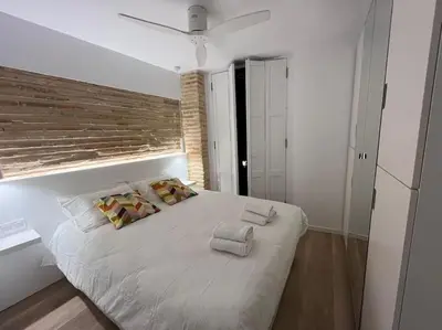 a bedroom with a large white bed with towels on it at Espectacular y luminoso apartamento en el centro in Valencia