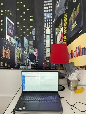 a laptop computer sitting on a desk with a red lamp at El estudio de las mariposas,sofa cama , cocina y baño in Partida de La Cañada