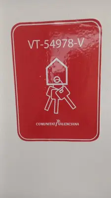 a red sign with a drawing of a person on it at El estudio de las mariposas,sofa cama , cocina y baño in Partida de La Cañada