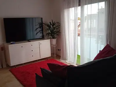 a living room with a tv on a white dresser at El estudio de las mariposas,sofa cama , cocina y baño in Partida de La Cañada