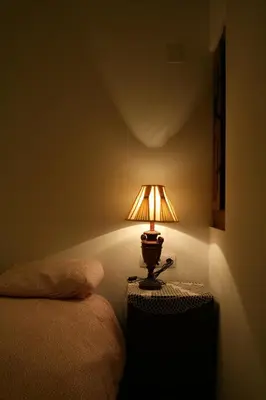 a lamp sitting on a table next to a bed at La Casita de Las Estrellas in Algimia de Almonacid