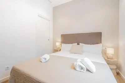 a bedroom with a white bed with towels on it at Mediterraneum Apto E in Valencia
