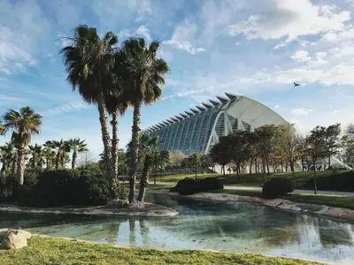 a view of a building with palm trees and a pond at Mediterraneum Apto E in Valencia