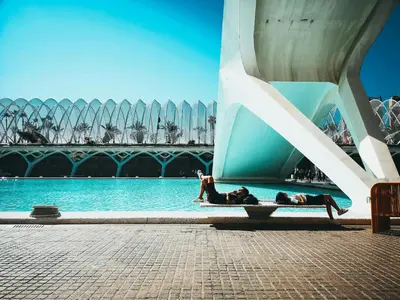 two people laying in the water next to a building at Mediterraneum Suite D in Valencia