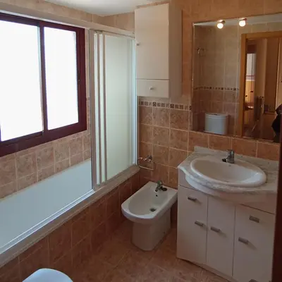 a bathroom with a sink and a toilet and a mirror at Apartamento 2 habitaciones playa de Canet de Berenguer in Canet de Berenguer