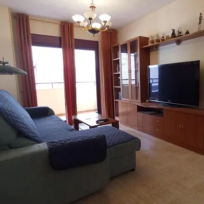 a living room with a couch and a flat screen tv at Apartamento 2 habitaciones playa de Canet de Berenguer in Canet de Berenguer