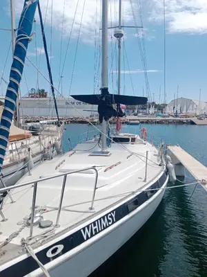 a white sailboat docked at a dock in the water at Velero Valencia Whimsy in Valencia