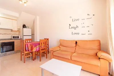 a living room with a couch and a table at Global Vacacional, Apartamento con terraza de 70m y piscina en Canet de Berenguer in Canet de Berenguer