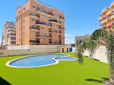 a swimming pool in front of a tall building at Global Vacacional, Apartamento con terraza de 70m y piscina en Canet de Berenguer in Canet de Berenguer
