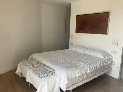 a white bed in a bedroom with a painting on the wall at molino rehabilitado con gran terraza y piscina in Paterna