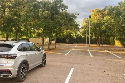 a white car parked in a parking lot at molino rehabilitado con gran terraza y piscina in Paterna