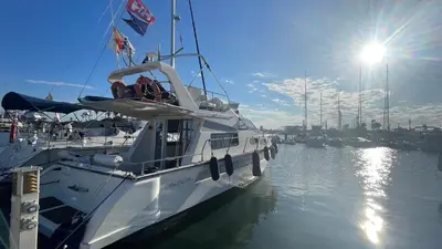 a white boat is docked in the water at Barco Apartamento Playa Valencia in Valencia