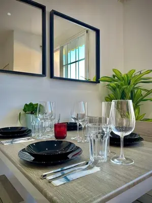 a table with glasses and plates and a mirror at Elegant Rooftop by F2 Rental Home in Valencia