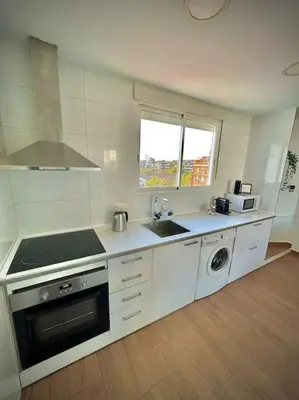 a white kitchen with a sink and a stove at Elegant Rooftop by F2 Rental Home in Valencia