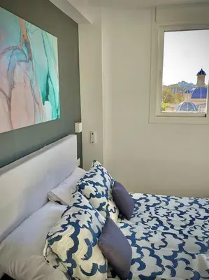 a bedroom with a bed with pillows and a window at Elegant Rooftop by F2 Rental Home in Valencia