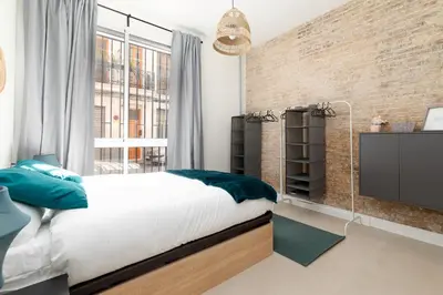 a bedroom with a bed and a brick wall at Apartamento Ruzafa 1 habitacion y 2 sofas cama in Valencia