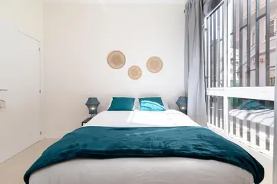 a bedroom with a large bed with blue pillows at Apartamento Ruzafa 1 habitacion y 2 sofas cama in Valencia