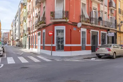 a red and white building on the side of a street at Apartamento Ruzafa 1 habitacion y 2 sofas cama in Valencia