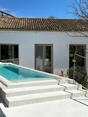 a white house with a swimming pool and stairs at Apartamento en molino con piscina in Paterna