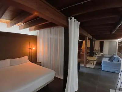 a bedroom with a bed and a living room at Apartamento en molino con piscina in Paterna