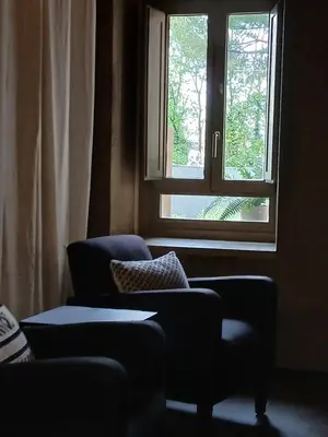 a living room with a chair and a window at Apartamento en molino con piscina in Paterna