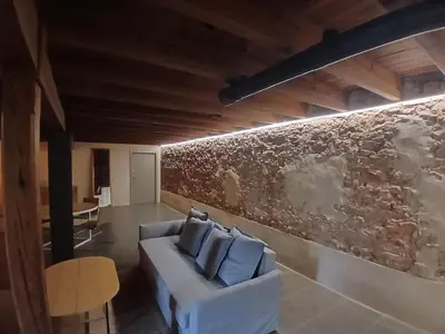 a living room with a white couch and a wall at Apartamento en molino con piscina in Paterna