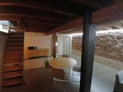 a room with a table and chairs and a staircase at Apartamento en molino con piscina in Paterna