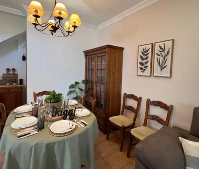a kitchen with wooden cabinets and a black refrigerator at Alojamiento Rural Ikigai in Losa del Obispo