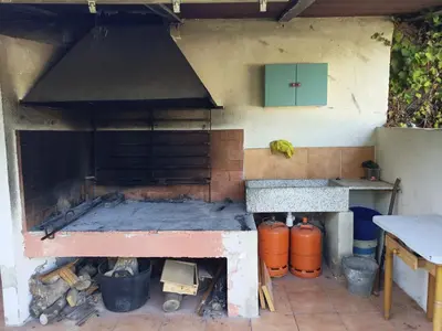 an outdoor kitchen with a grill and a stove at Chalet con piscina LUA HOME in Manises