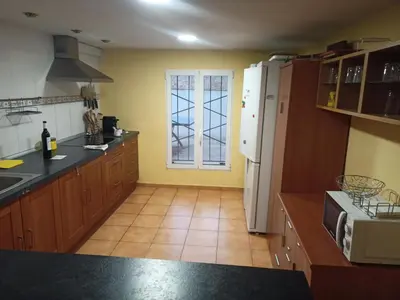 a kitchen with wooden cabinets and a white refrigerator at Chalet con piscina LUA HOME in Manises