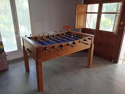 a large wooden foosball table in a room at Chalet con piscina LUA HOME in Manises