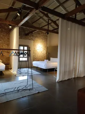 a room with two beds and a white curtain at Ático loft en molino antiguo in Paterna