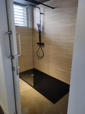a shower in a room with a glass wall at Ático loft en molino antiguo in Paterna