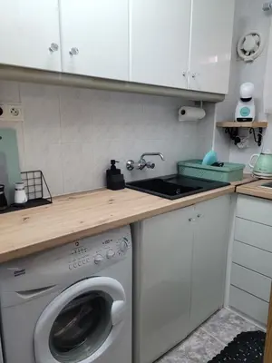 a kitchen with a washing machine under a counter at TIGA muy cerca de la plaza de San Antonio in Cullera
