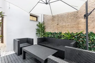 a patio with a bench and an umbrella at Ruzafa Market, 2 Rooms, 5 pax,wifi ACTerrace 5 Pax in Valencia