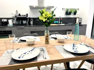 a wooden table with plates and a vase of flowers at Ruzafa Market, 2 Rooms, 5 pax,wifi ACTerrace 5 Pax in Valencia