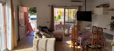a living room with a couch and a table at Adosado playa Pobla Farnals in Puebla de Farnals