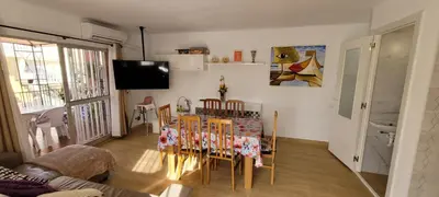 a dining room with a table and chairs and a television at Adosado playa Pobla Farnals in Puebla de Farnals