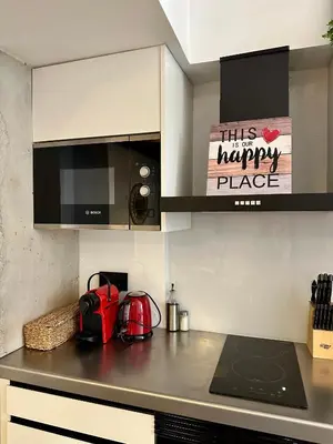 a kitchen with ahappyhappy place sign on the counter at Loft Camp del Turia A5 - Housevanlive in Valencia