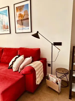 a red couch in a living room with a lamp at Loft Camp del Turia A5 - Housevanlive in Valencia